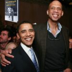 Two men posing for a picture in front of a crowd.