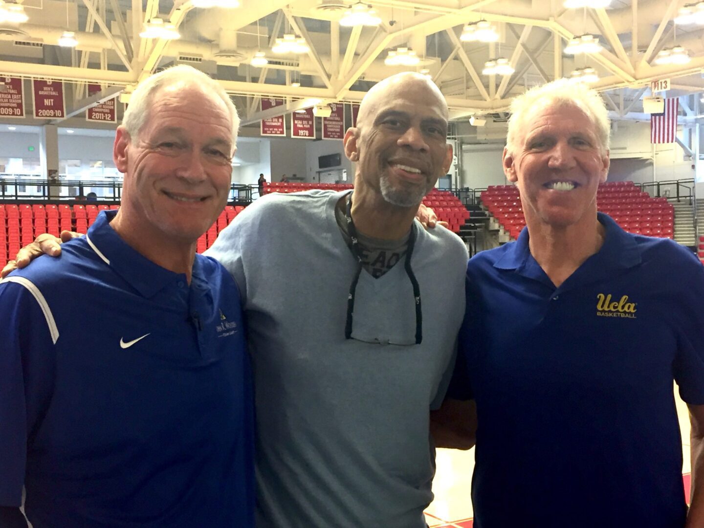 22-3 Three men standing next to each other in a gym.