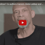 A bald man with a beard is talking to the camera.