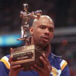 A man holding a trophy and wearing a uniform.