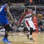 A basketball player is playing against another player.