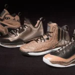 A row of different colored basketball shoes on top of a black surface.