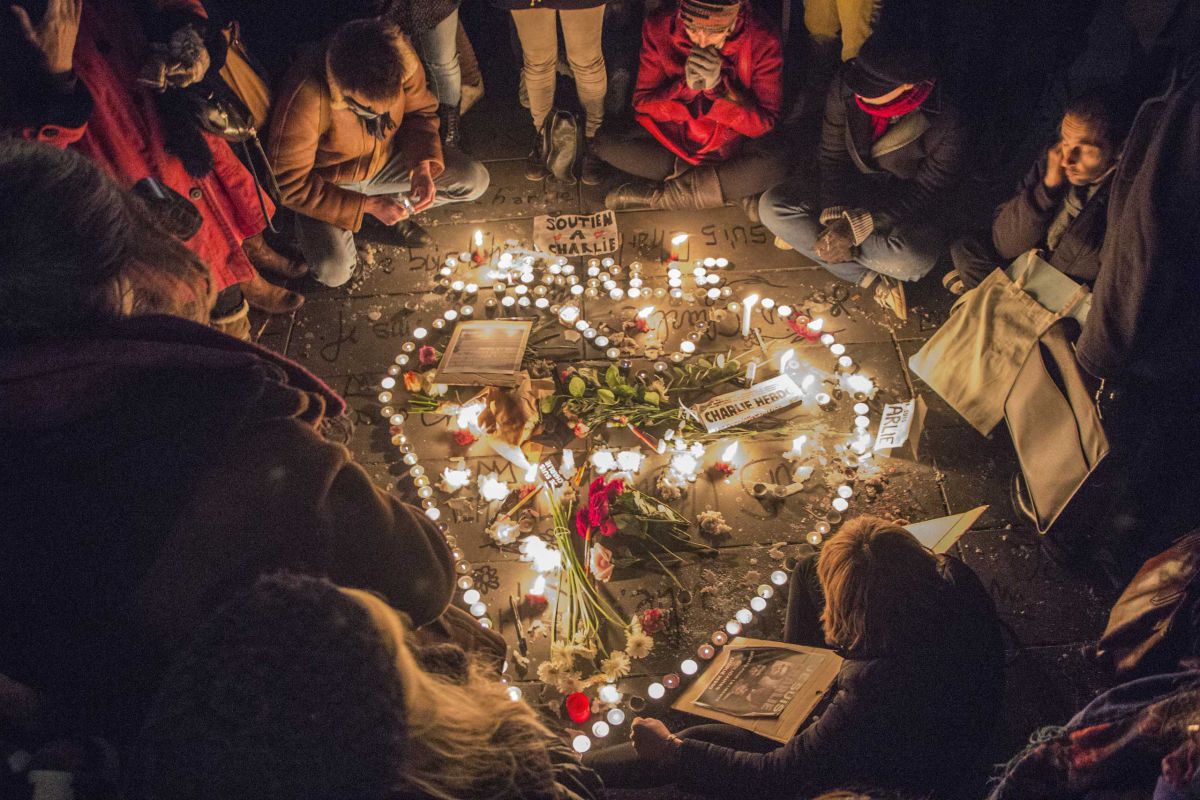 A group of people sitting around candles and flowers.