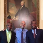 Three men in suits posing for a picture.