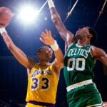 Two basketball players are playing a game of basketball.