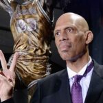 A bald man in a suit and purple tie.