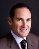A man in suit and tie smiling for the camera.