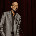 A man in a suit and tie standing on stage.