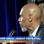 A man with a bald head and beard is speaking.